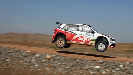 Un Skoda pilotado por Gill Gaurav y copilotado por Macneall Glenn patrocinado por MRF Tyres en un salto en un rally de tierra en China